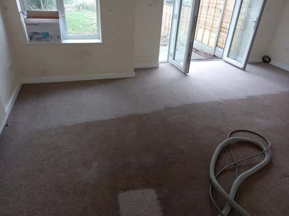 This is a photo of an empty living room with a brown carpet that is in the process of having its carpets steam cleaned works carried out by Abbots Langley Carpet Cleaning