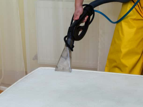 This is a photo of a man steam cleaning a dirty mattress works carried out by Abbots Langley Carpet Cleaning