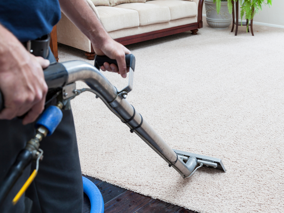 This is a photo of a man with a steam cleaner cleaning a cream carpet works carried out by Abbots Langley Carpet Cleaning